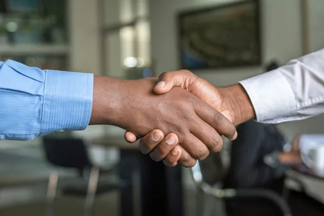 Twee mensen schudden elkaar de hand na een zakelijk gesprek