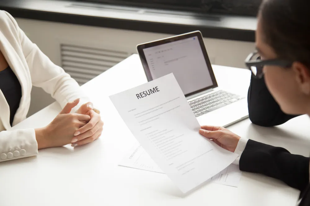 Recruiter bekijkt een cv tijdens een sollicitatiegesprek